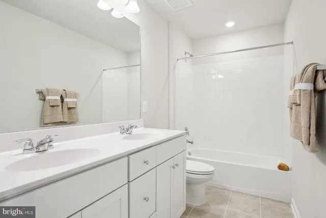 a bathroom with a granite countertop sink a toilet and shower