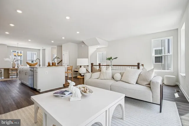 a living room with furniture and a dining table with wooden floor