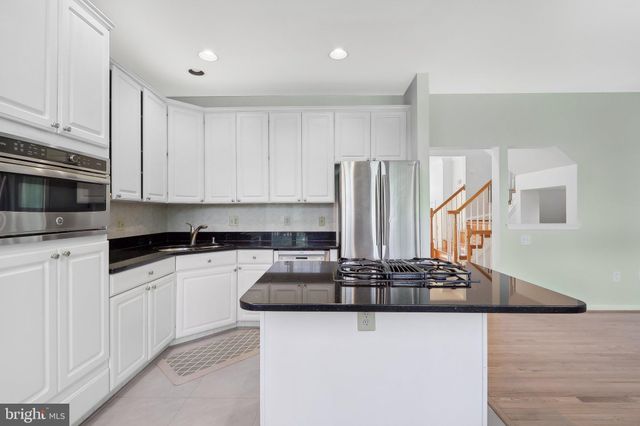 a kitchen with granite countertop a sink stove and refrigerator