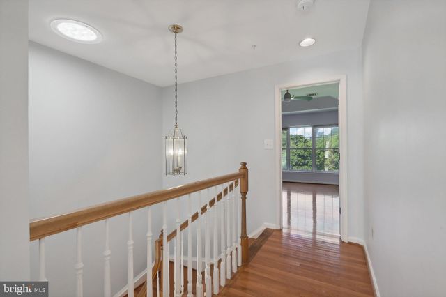 a view of a hallway with wooden floor and stairs