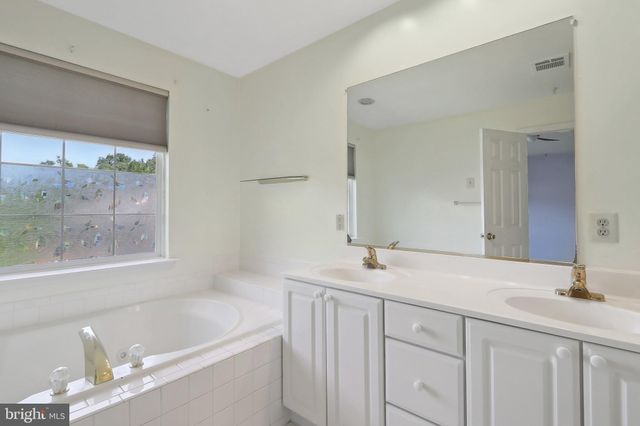a bathroom with a granite countertop sink mirror and a bathtub