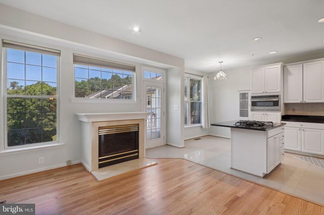 a kitchen with stainless steel appliances granite countertop a stove top oven a sink and a wooden floors