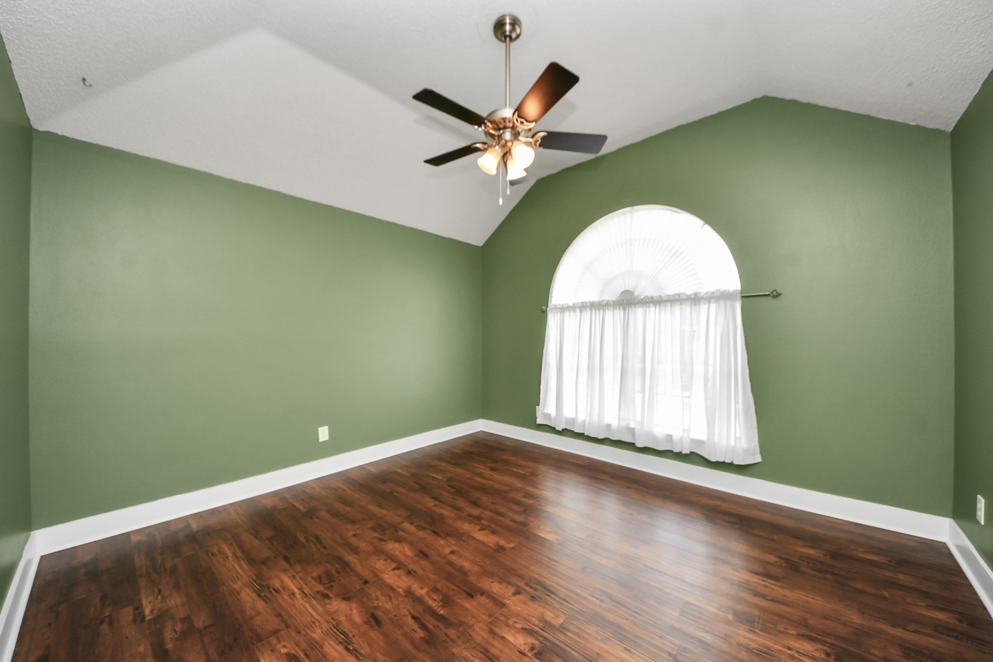 3107 Dulaney Road Houston, TX 77084 - Photo 34 of 50 an empty room with wooden floor windows and fan