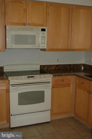 a stove top oven sitting inside of a kitchen