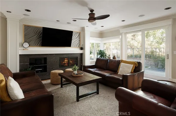 a living room with furniture a flat screen tv and a fireplace