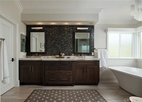 a bathroom with a double vanity sink mirror and bathtub