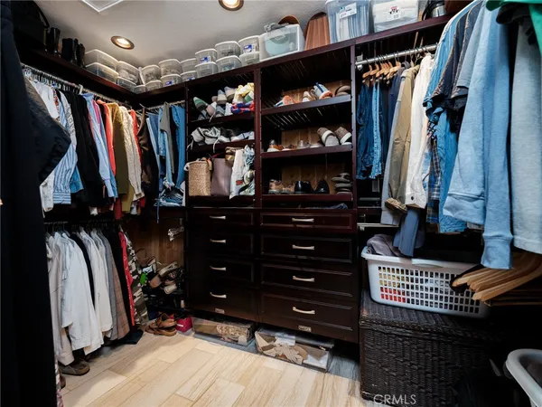 a view of walk in closet with clothes and shoes