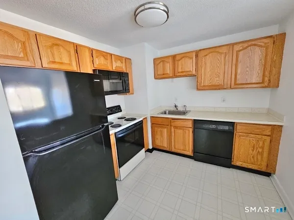 a kitchen with granite countertop stainless steel appliances and wooden cabinets