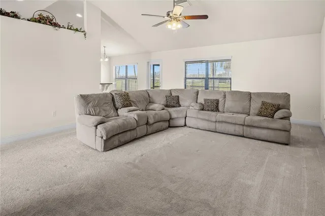 a living room with furniture and a ceiling fan