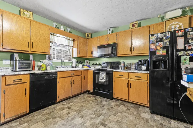 a kitchen with stainless steel appliances granite countertop a refrigerator and a stove top oven