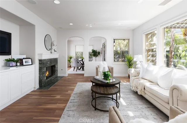 a living room with furniture a fireplace and a large window