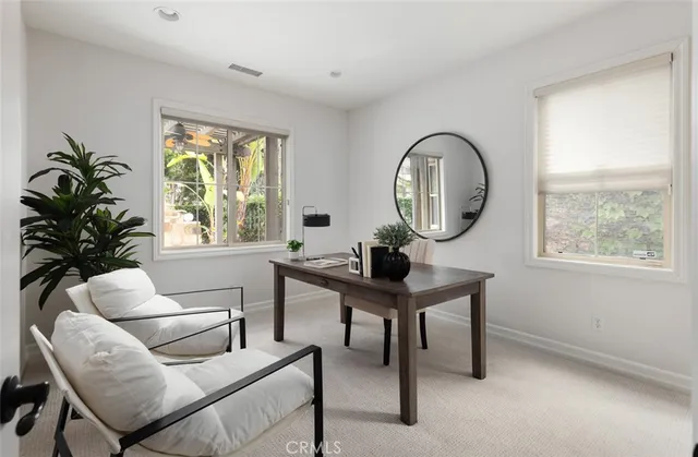 a living room with furniture a window and a potted plant