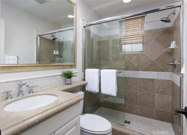 a bathroom with a sink toilet a mirror and shower