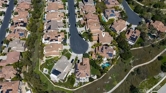an aerial view of a city with lots of residential buildings and mountain view in back