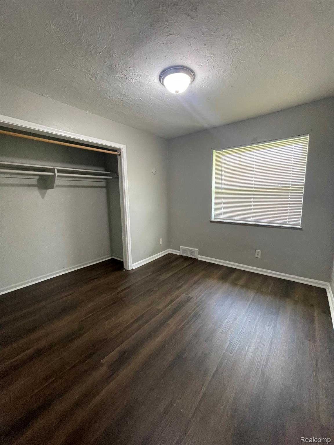19800 Berg Road Detroit, MI 48219 - Photo 8 of 13 Room featuring dark wood-finish flooring, light grey walls, and a recessed window with blinds