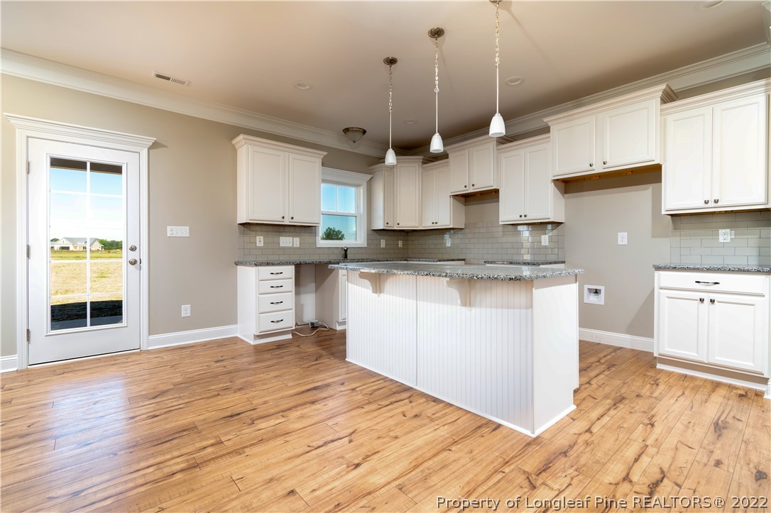 5229 Bree Bridge Road Hope Mills, NC 28348 - Photo 7 of 18 a kitchen with stainless steel appliances granite countertop a sink a stove and a wooden floors