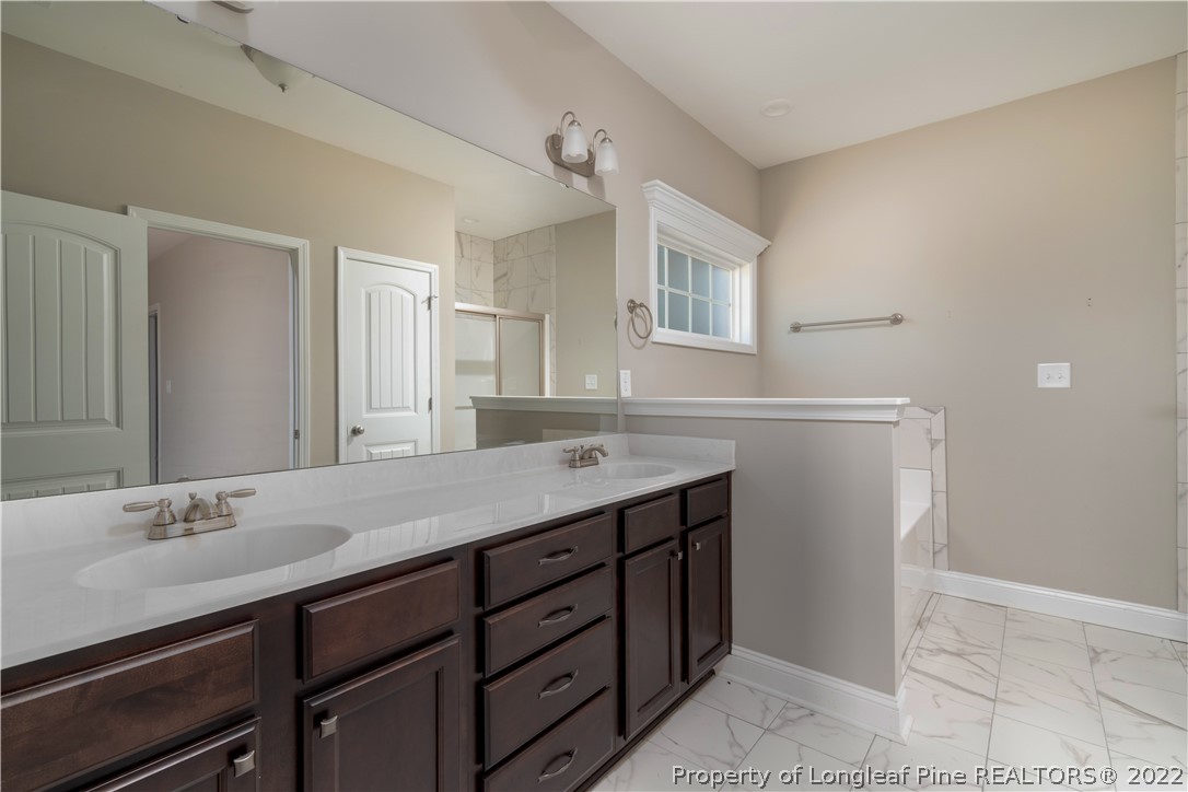 5229 Bree Bridge Road Hope Mills, NC 28348 - Photo 10 of 18 a bathroom with a granite countertop sink and a mirror