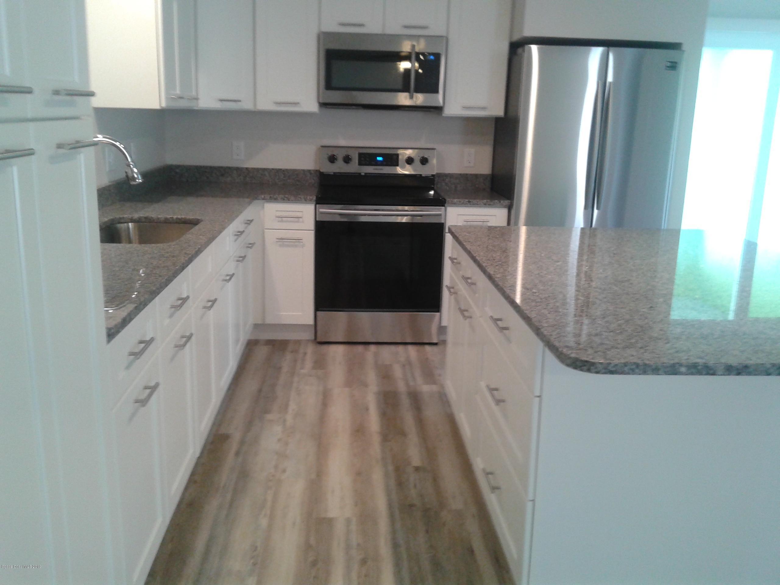 1851 Keewin Avenue, Unit 2 Palm Bay, FL 32905 - Photo 5 of 15 a kitchen with granite countertop a refrigerator stove and sink