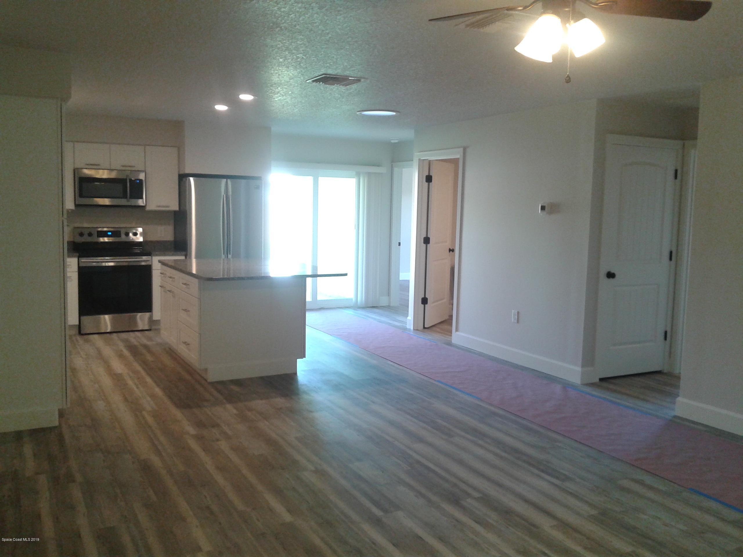 1851 Keewin Avenue, Unit 2 Palm Bay, FL 32905 - Photo 6 of 15 a kitchen with stainless steel appliances granite countertop a refrigerator and a stove top oven