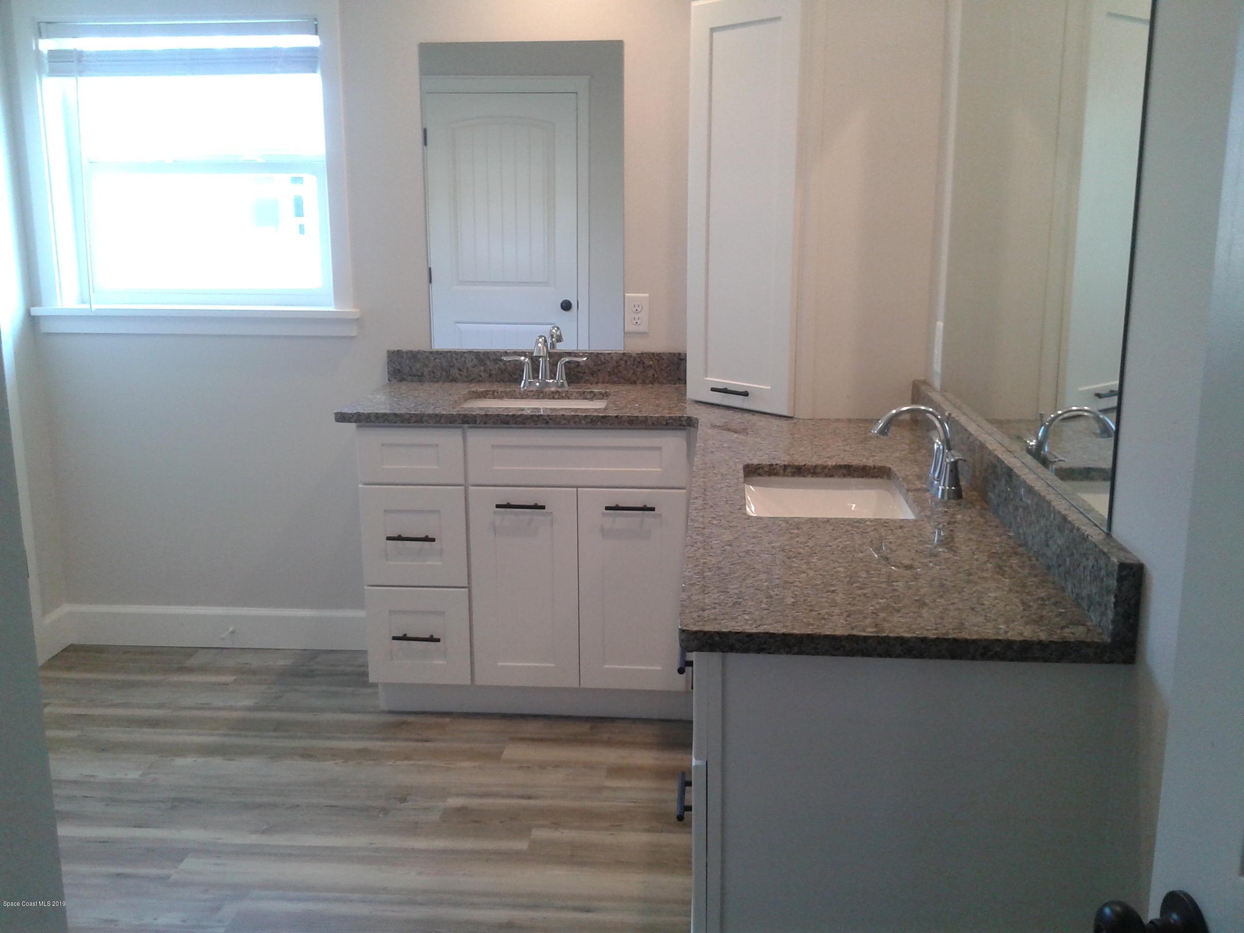 1851 Keewin Avenue, Unit 2 Palm Bay, FL 32905 - Photo 9 of 15 a bathroom with a granite countertop sink and a mirror