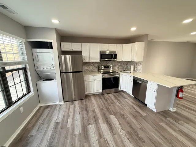 a kitchen with stainless steel appliances a refrigerator sink and microwave