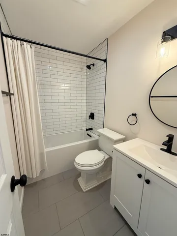 a bathroom with a toilet sink vanity tub and shower