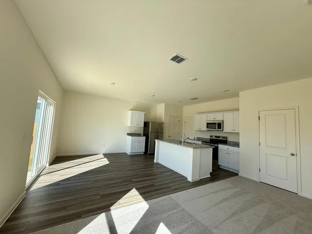 a view of a kitchen with a sink and dishwasher stove refrigerator with wooden floor