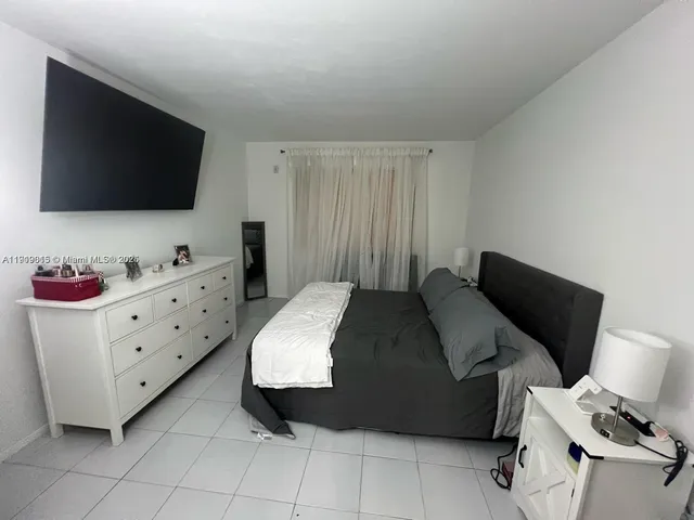 a bedroom with a bed and flat screen tv