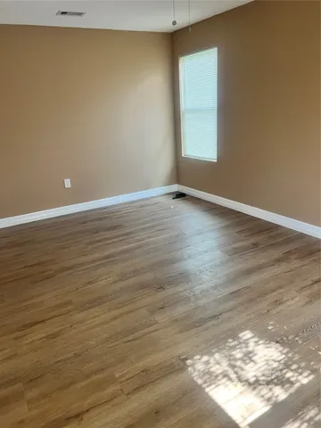 a view of a room with wooden floor and window