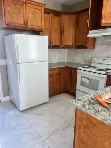 a kitchen with a refrigerator sink and cabinets