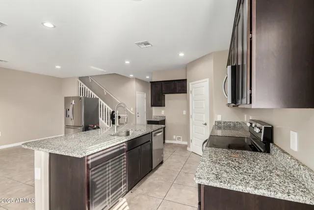 a kitchen with stainless steel appliances granite countertop a sink stove and refrigerator