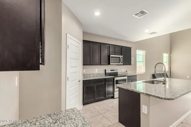 a kitchen with stainless steel appliances granite countertop a sink stove and refrigerator