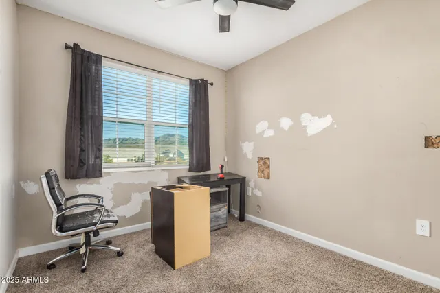 a view of a workspace with furniture and a window