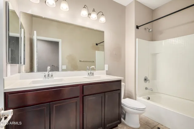 a bathroom with a double vanity sink toilet mirror and bathtub