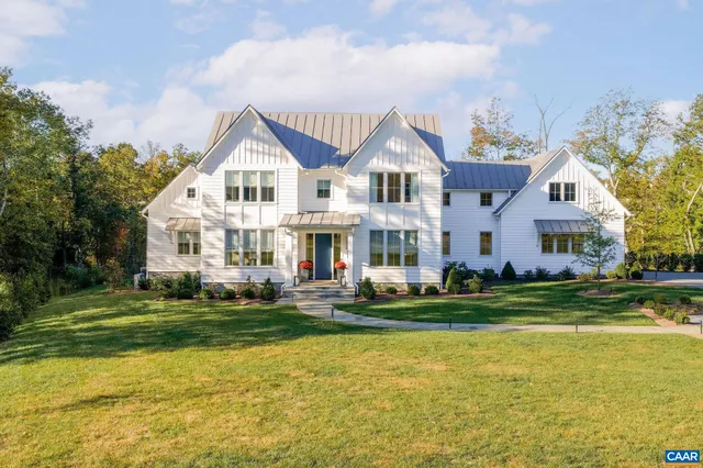 a view of a big house with a big yard and potted plants