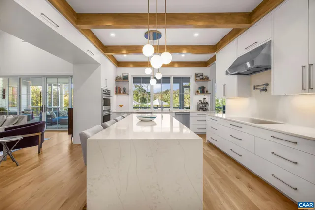a view of kitchen with stainless steel appliances kitchen island granite countertop a stove and a sink