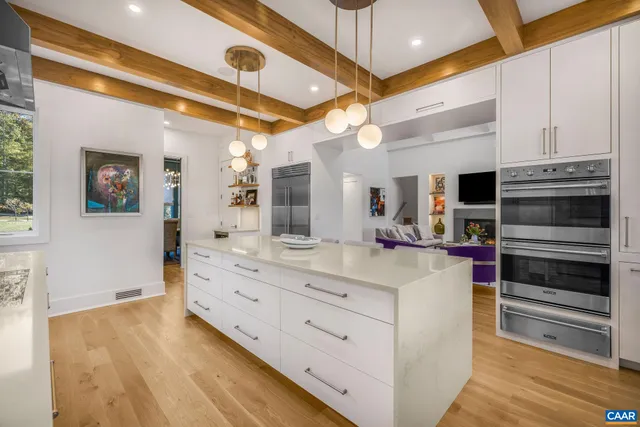 a living room with furniture fireplace and large window