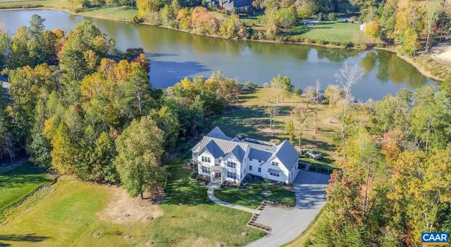 an aerial view of residential houses with outdoor space and lake view