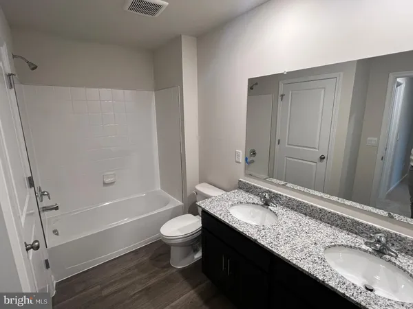 a spacious bathroom with a granite countertop sink and a mirror