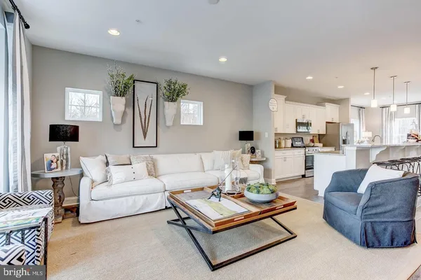 a living room with furniture kitchen and a table