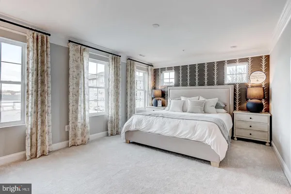 a spacious bedroom with a bed and large windows