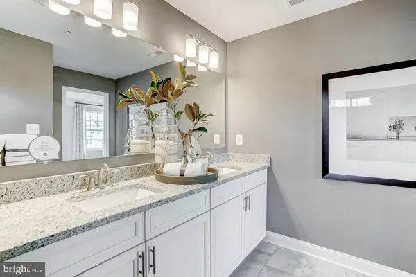 a bathroom with double vanity sinks and a mirror