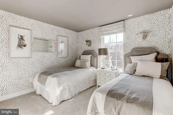 a bedroom with two beds and two large window