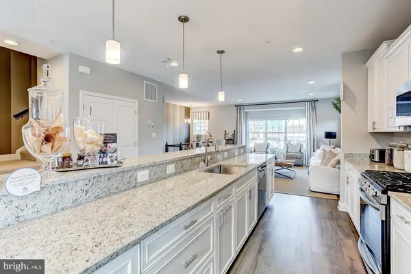 a large kitchen with kitchen island a stove a sink a center island and couches