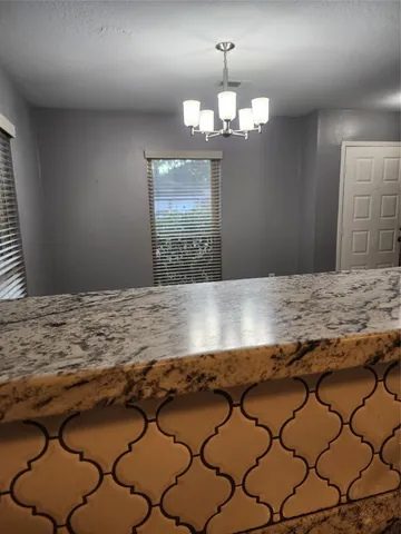 a view of an empty room with stairs and a window