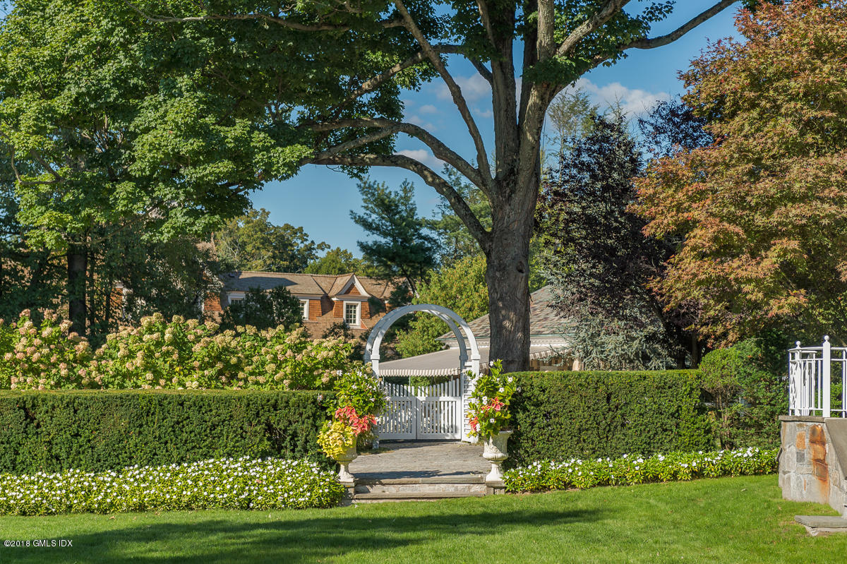 16 Rock Ridge Avenue Greenwich, CT 06831 - Photo 44 of 57 a front view of a house with a garden and trees
