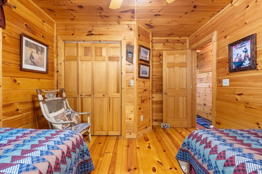 293 Broken Arrow Path Blue Ridge, GA 30513 - Photo 18 of 48 a bedroom with a bed and wooden floor