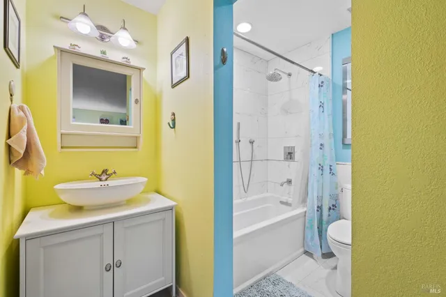 a bathroom with a bathtub sink vanity mirror and toilet