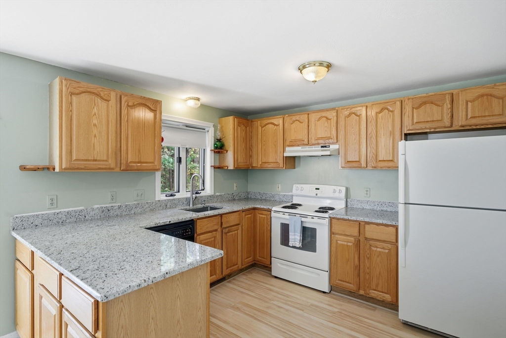 55 Littleton Road, Unit 15A Ayer, MA 01432 - Photo 8 of 37 a kitchen with stainless steel appliances granite countertop a sink stove and refrigerator
