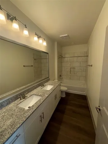a bathroom with a granite countertop sink and a shower